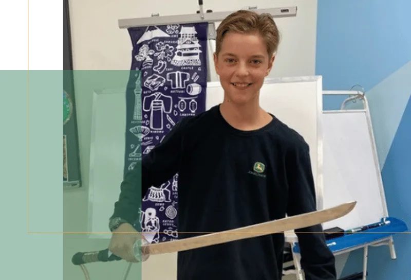 a boy hold a sword that he made