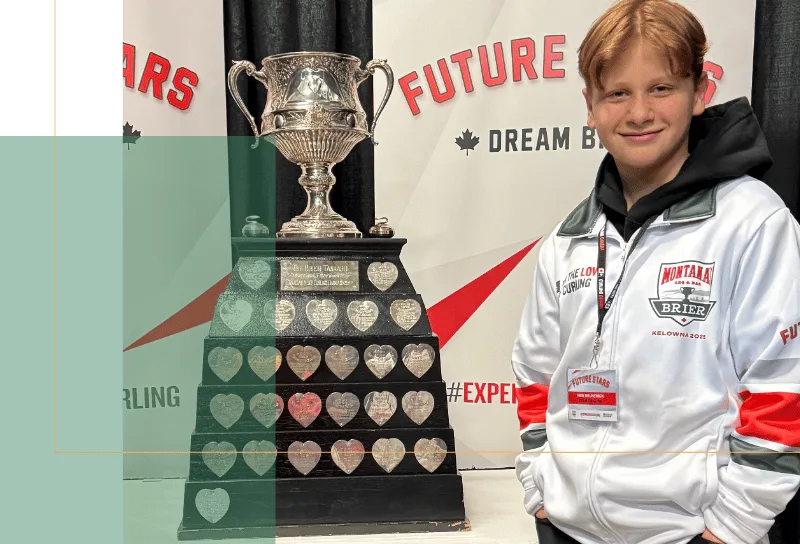 A boy standing with a trophy