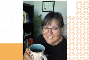 Toni holding a cup of coffee and smiling