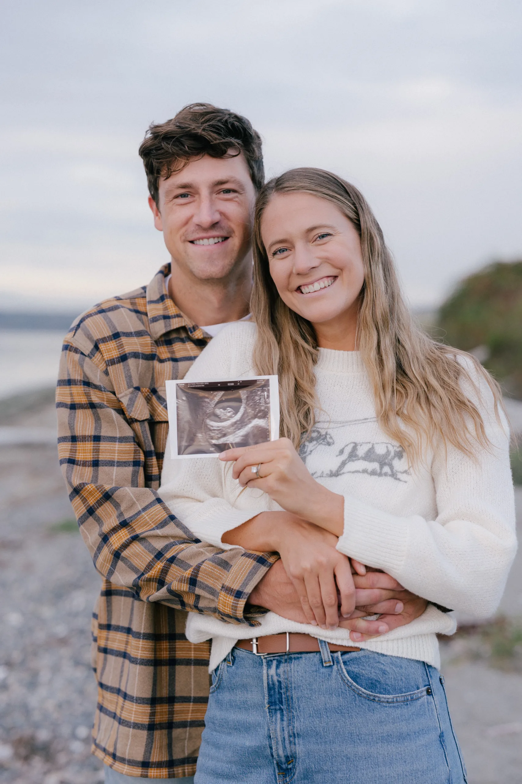 Brie and her husband with an ultrasound photo of a baby