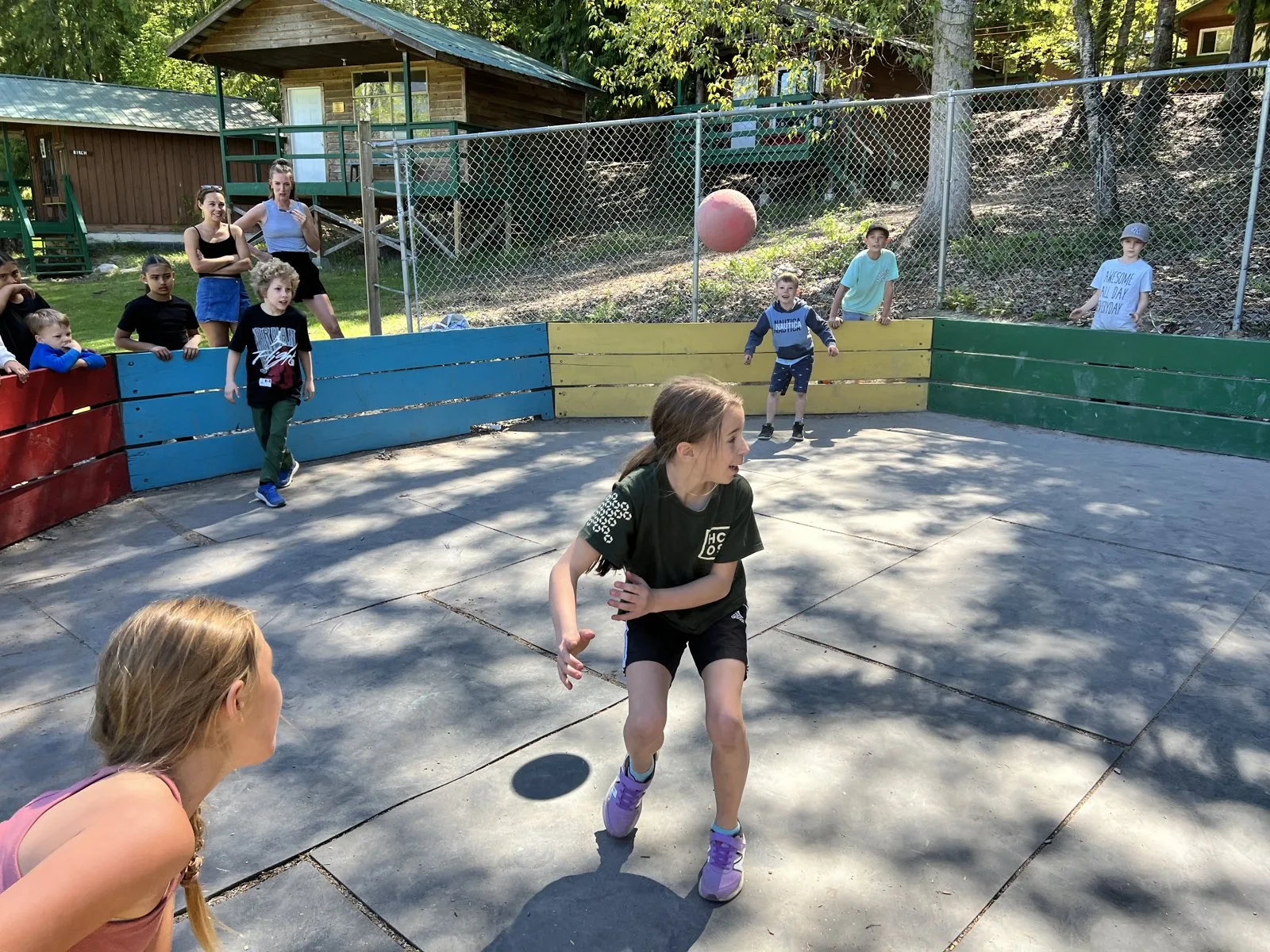 Students playing a ball game in an outdoor gaga pit at camp