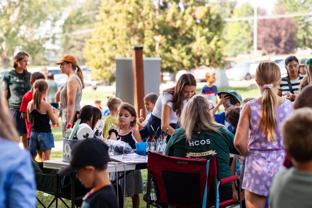 Families and students at an outdoor HCOS community event