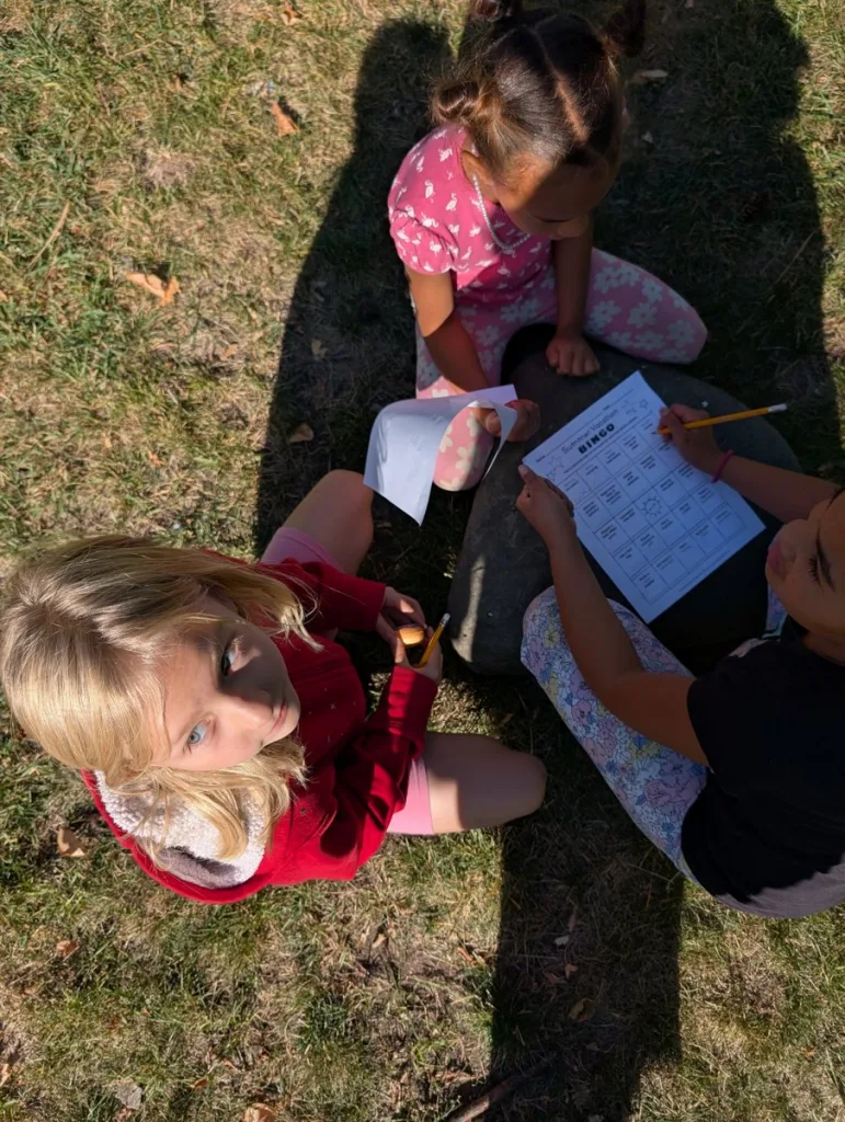 Children doing worksheets together on the grass