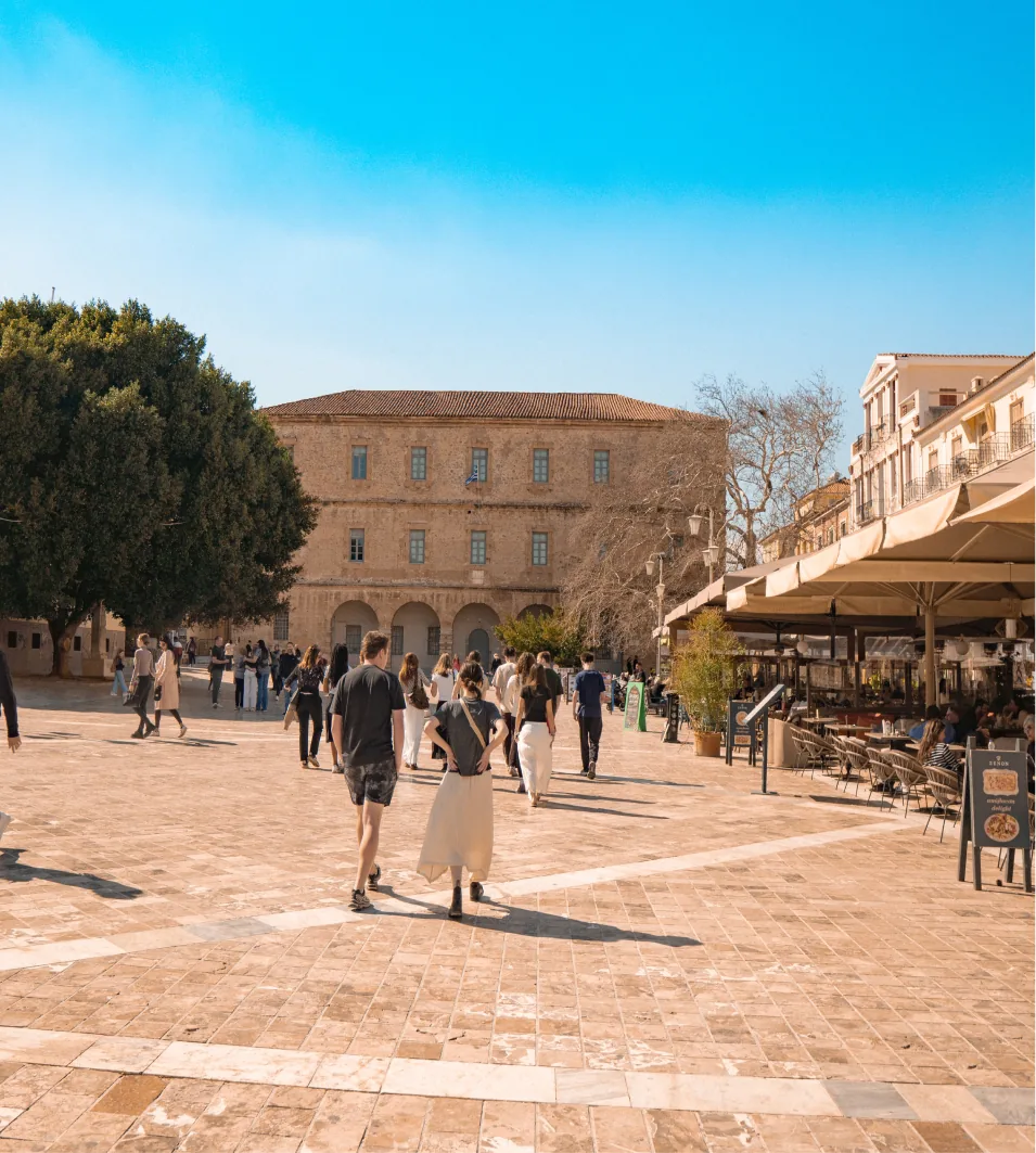 Students walking across a sunny European plaza