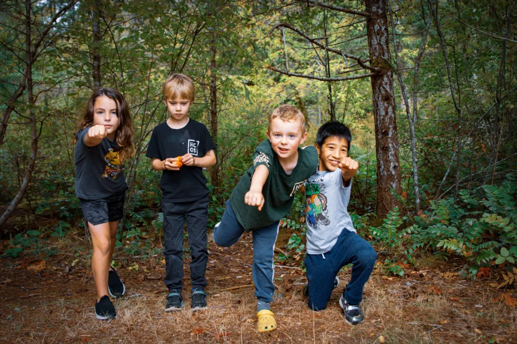 Four HCOS students posing playfully in a forest
